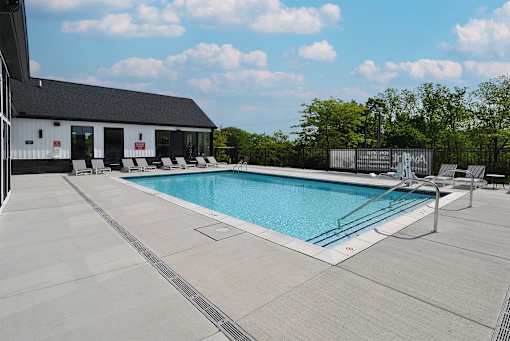 A large outdoor swimming pool with a building in the background.