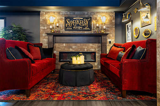 A living room with red couches and a fireplace.