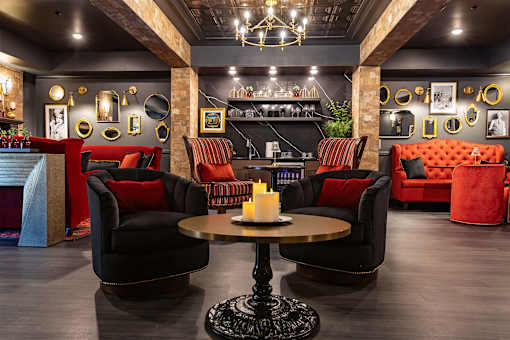 A room with a black table and chairs with red cushions.