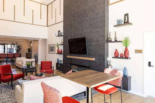 A living room with a fireplace and a TV on the wall.