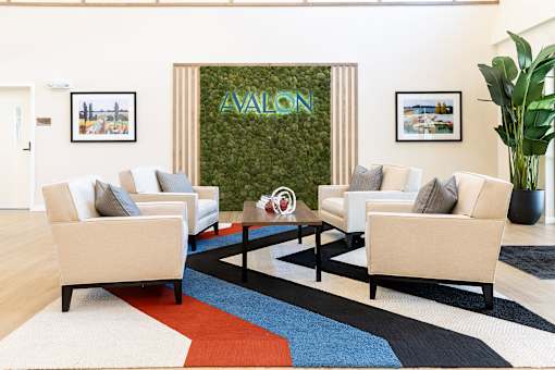 A living room with a green wall and white couches.