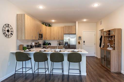 A kitchen with a white countertop and a clock on the wall.