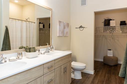 A bathroom with a toilet, sink, and mirror.