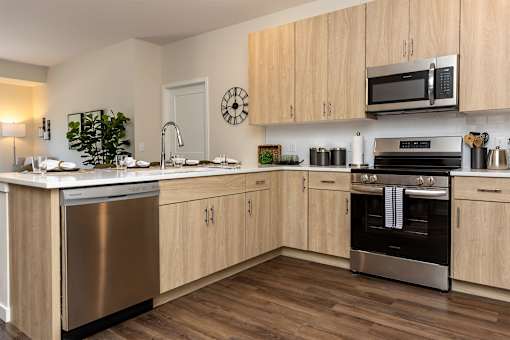A modern kitchen with wooden cabinets and stainless steel appliances.