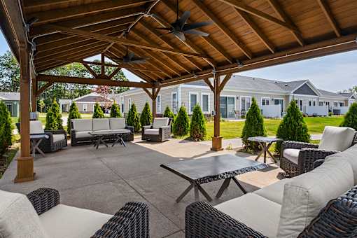 A patio with a table and chairs under a roof.
