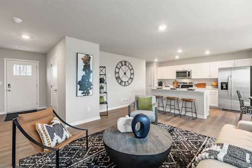 A modern living room with a large clock on the wall.