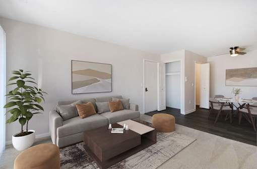 A living room with a grey couch, a brown coffee table, and a large painting on the wall.