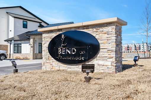 A sign that says Bend on Promenade in front of a building.