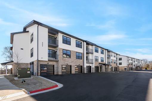A row of modern townhouses with garages and driveways.