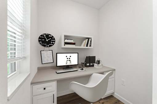 A white desk with a computer and a white chair in a room.