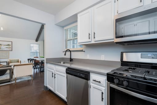 apartment property resident club house community kitchen with white cabinets and stainless steel appliances