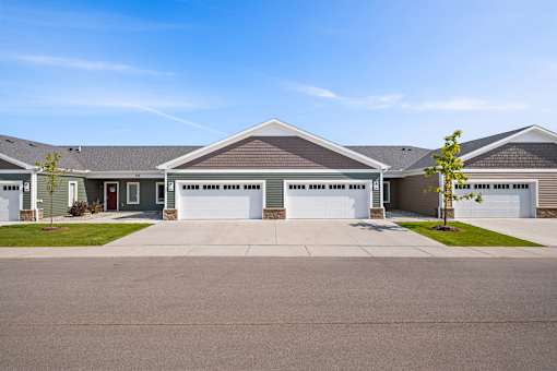 A row of houses with garages and driveways.