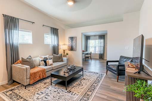A living room with a couch, chair, and television.