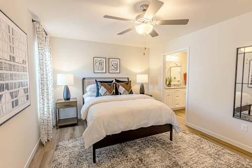A bedroom with a large bed and a ceiling fan.