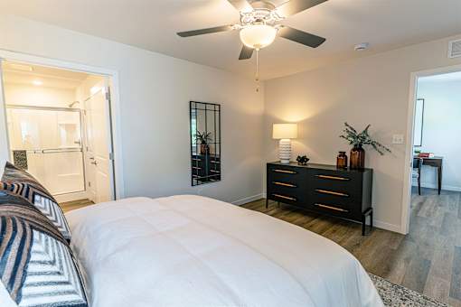 A bedroom with a large bed and a ceiling fan.