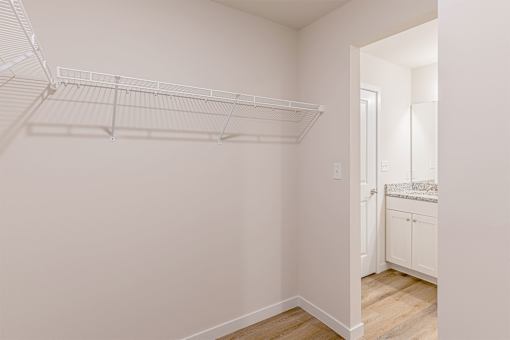 A white wall with a white shelf and a white door.