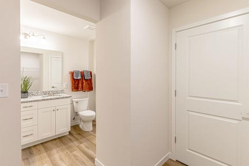 A bathroom with a toilet, sink, and a white door.