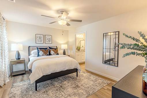A bedroom with a large bed and a ceiling fan.