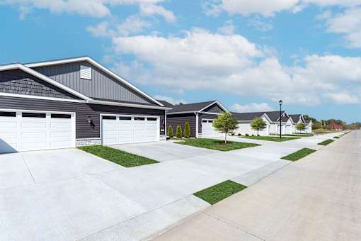 A row of houses with garages and driveways.