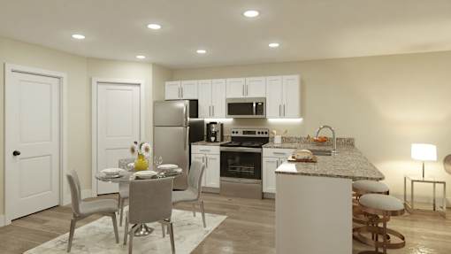A kitchen with a table and chairs in front of it.
