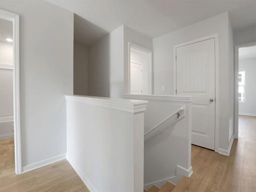 A white staircase with a landing in a house.