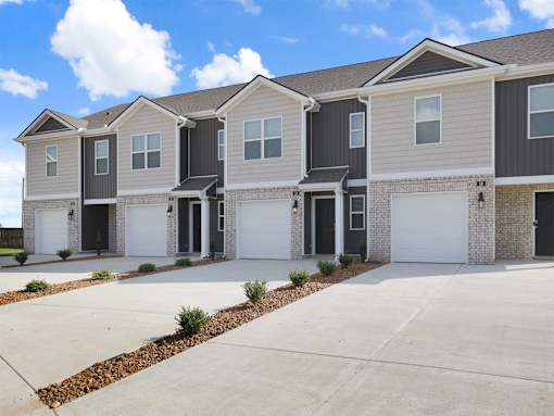 A row of modern houses with garages and driveways.