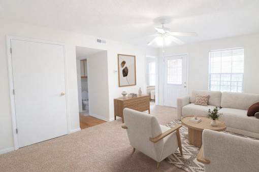 A living room with a white couch, a coffee table, and a ceiling fan.
