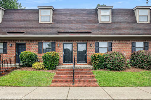 A red brick house with a black door and windows.