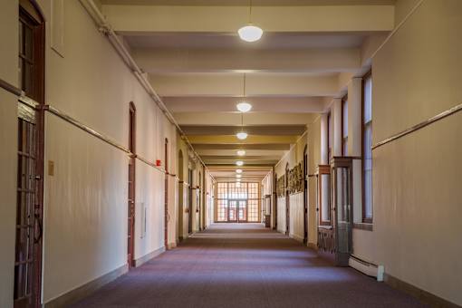 A long hallway with doors on both sides and a light at the end.