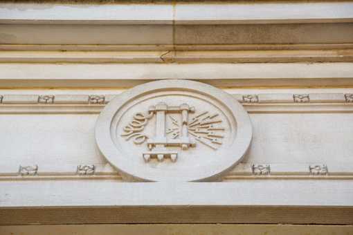 A decorative emblem with a shield and a cross is centered on a wall.