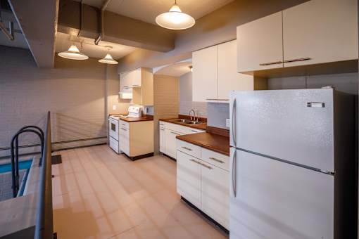 A kitchen with white appliances and wooden countertops.