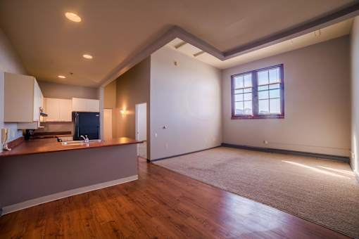 A room with a window and a kitchen area.