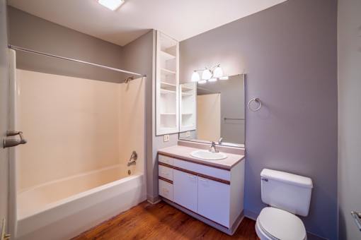 A white bathroom with a toilet, sink, and bathtub.