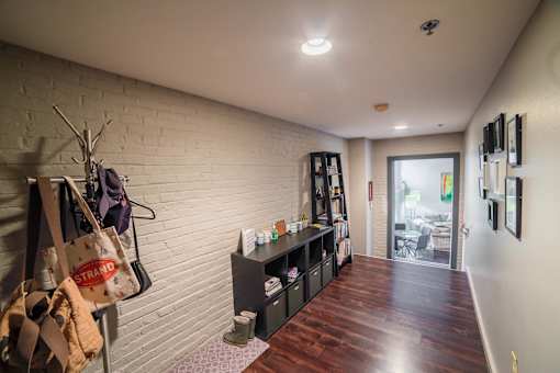 A room with a white brick wall and a wooden floor.