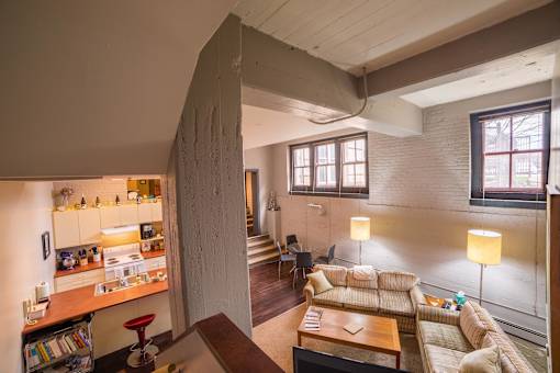 A living room with a couch, a table, and a lamp.