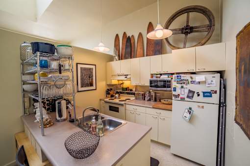 A kitchen with a white refrigerator and a white sink.