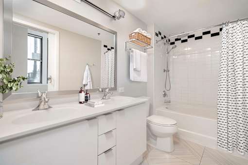 A white bathroom with a toilet, sink, and shower.