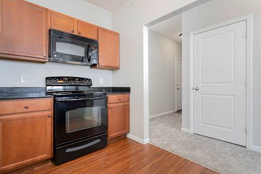 A kitchen with wooden cabinets and a black stove top oven.
