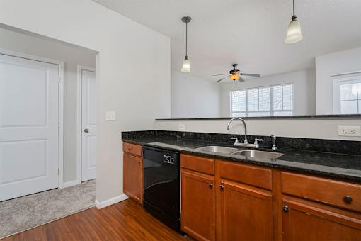 A kitchen with wooden cabinets and a black countertop.