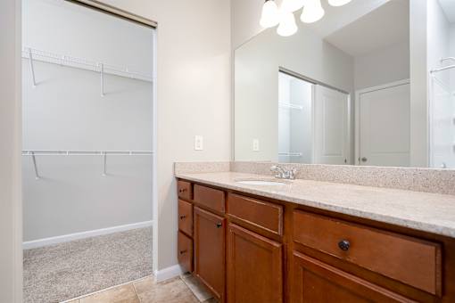 A bathroom with a vanity, sink, and mirror.