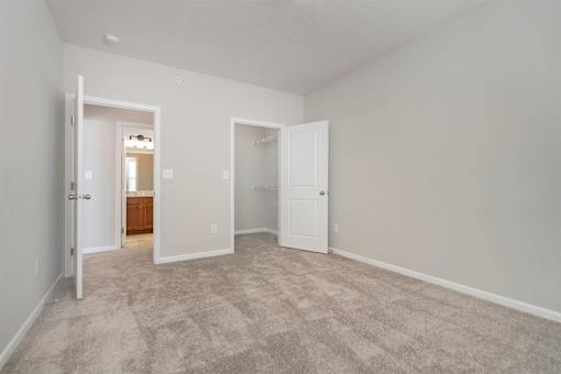 A room with carpeted floor and two doors.