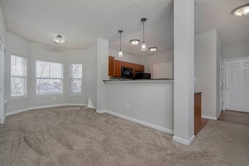 A spacious living room with a bar area and a door on the right.
