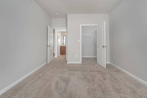 A long hallway with carpeted floors and white walls.