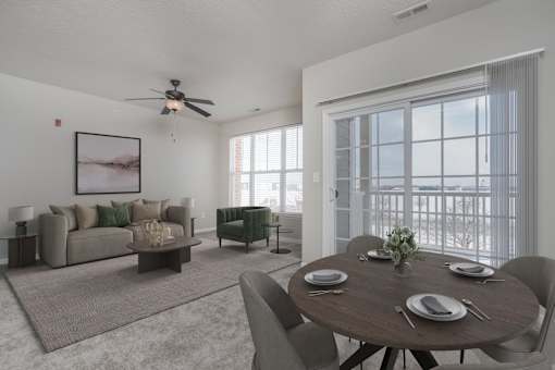 A living room with a brown couch, a coffee table, and a dining table set for four.