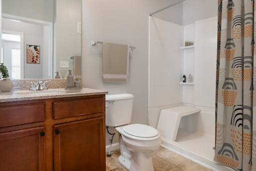 A bathroom with a toilet, sink, and shower.
