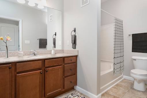 A bathroom with a white toilet and a wooden vanity.