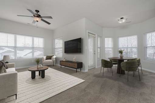 A living room with a television, a couch, a chair, a coffee table, and a rug.