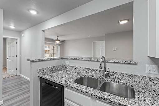 A modern kitchen with granite countertops and stainless steel appliances.