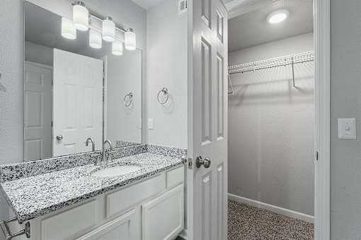 A bathroom with a granite countertop and a white door.