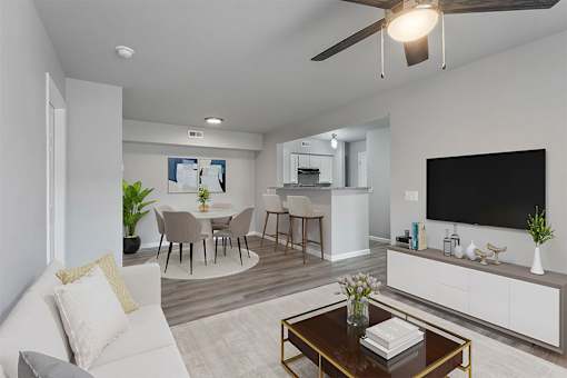 A modern living room with a white couch, a coffee table, and a flat-screen TV.
